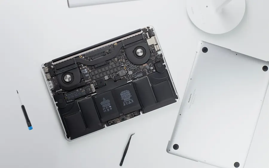 Portable ouvert sur un établi propre, avec outils de précision.