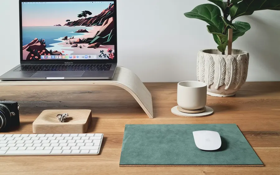 Portable récent sur un support en bois, bureau épuré.